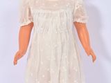 une image représentant une poupée vêtue d'une robe blanche et de chaussures blanches