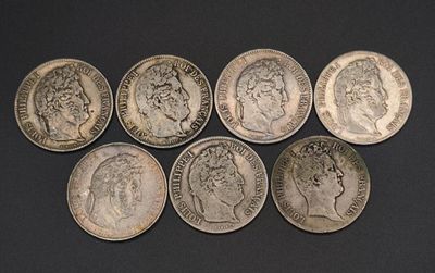 six different types of silver coins on a black surface