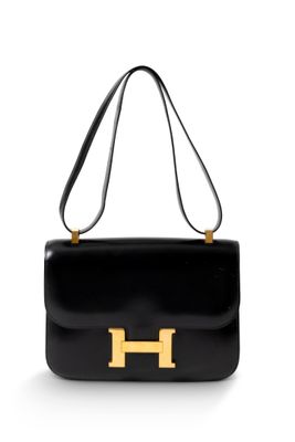 un sac à main noir avec des finitions dorées sur la poignée