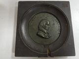 a small metal plate with a picture of a man on it