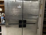 a stainless steel refrigerator in a kitchen with a lot of clutter on the floor