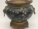 a black vase with a floral design on it