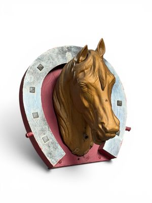 une tête de cheval accrochée au mur avec un fer à cheval