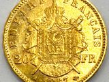 a close up of a gold coin on a white surface