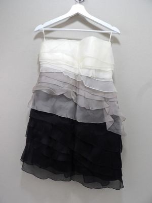 une robe noire et blanche suspendue à un cintre devant un mur blanc