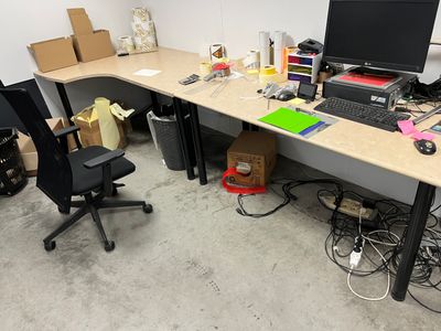 a desk with a computer and a chair in a room