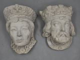 pair of carved heads of two men with crowns on their heads