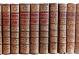 plusieurs vieux livres sont alignés sur une surface blanche