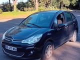 une petite voiture noire garée sur le bord de la route