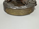 bronze statue of a woman sitting on top of a tree stump