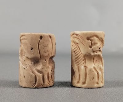 une paire de figurines anciennes en pierre représentant un homme et une femme