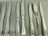 a lot of silverware on a table with a knife and fork