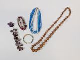 a lot of beads and bracelets on a white surface