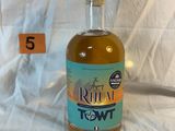 a bottle of liquor sitting on a bed with a price tag