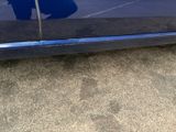 a blue car parked in a parking lot next to a parking lot