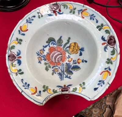 Plat à barbe en faïence à décor de fleurs - Accidents et égr…