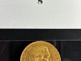 a close up of a gold coin on a black surface