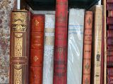 many old books in a wooden box on a shelf
