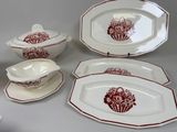several pieces of red and white dinnerware on a table