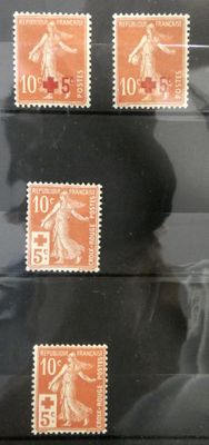 Quatre timbres de tailles et de couleurs différentes sont exposés dans une vitrine.