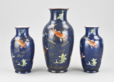 trois vases décorés de poissons, posés sur une table