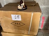 une petite figurine posée sur une boîte en carton