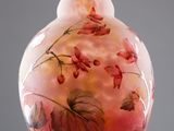 a glass vase with flowers painted on it on a stand