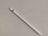 the white pen is laying on the table next to the white paper