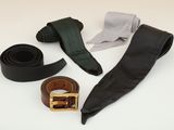 a belt, tie, and other accessories laid out on a table