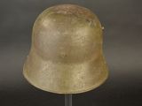 an old helmet on a stand on a gray background