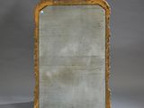 an antique mirror with a gold frame on a grey background