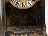 a black and gold clock with blue and white roman numerals on it