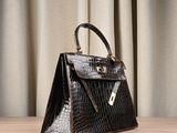 a brown purse sitting on top of a wooden table next to a curtain