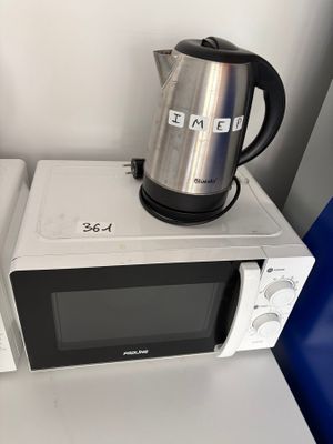 un micro-ondes et une bouilloire posée sur le micro-ondes