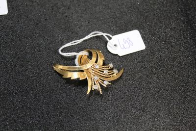 a gold brooch on a black surface with a price tag
