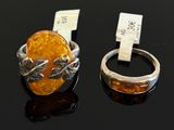 pair of silver and amber rings on black surface with price tag