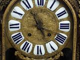 a gold clock with black and white roman numerals on it