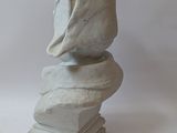 a white sculpture of a shell on top of a stack of books