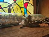 un bateau dans une bouteille et une paire de ciseaux posés sur une table