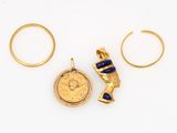 two gold rings and a gold pendant with a blue stone