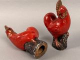 two red rooster figurines sitting next to each other