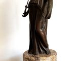 une statue représentant une femme tenant une épée, posée sur un socle
