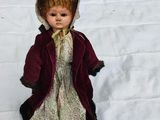 a doll that is sitting in the snow on the ground