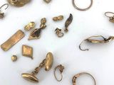 a lot of gold jewelry on a white surface