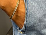 the woman is wearing a gold bracelet with a diamond on it