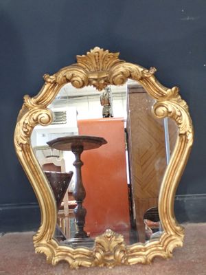 un miroir posé par terre à côté d'une table