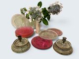 many different colored glass plates and vases on the table