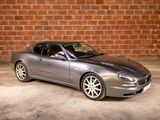 a silver sports car parked in front of a brick wall