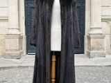 un manteau de fourrure posé sur un mannequin devant un immeuble
