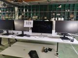 trois écrans d'ordinateur posés sur une table dans une pièce